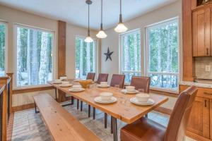 comedor con mesa, sillas y ventanas en Chalet am Berg en Government Camp