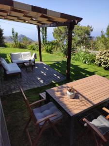 a patio with a wooden table and chairs under a pergola at Chálari in Raches