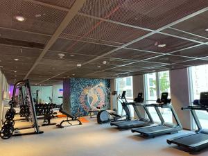 a gym with several treadmills and elliptical machines at Dubai Hills Estate Deluxe 2 bedroom Apartment Collective Tower A 603 in Dubai