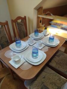 a wooden table with plates and glasses on it at Chalupa pod lipami in Terchová