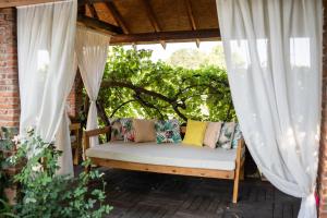 a swing on a porch with white curtains at Mogla Tashan Hotel in Mugla
