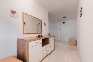 eine Küche mit weißen Schränken und einem Wandspiegel in der Unterkunft Apartman Luka in Molat