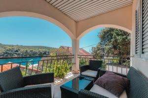 a balcony with chairs and a view of the water at Apartman Luka in Molat