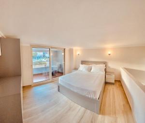 - une chambre blanche avec un lit et une grande fenêtre dans l'établissement Flors Apartments, à Durrës