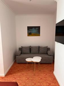 uma sala de estar com um sofá e duas mesas em ART HOTEL HOUSE ONE em Baden-Baden