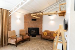 a living room with two couches and a fireplace at Mogla Tashan Hotel in Muğla