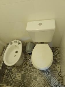 a bathroom with a white toilet and a sink at Aires de mar in San Clemente del Tuyú