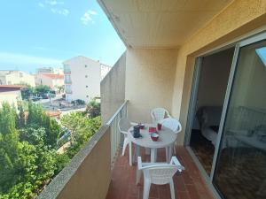 balkon ze stołem i krzesłami w obiekcie Appartement pour 4 personnes à 50m de la plage Narbonne Plage 4LP2A8 w mieście Narbonne-Plage