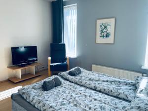 a bedroom with two beds and a tv and a chair at Tallinn Seaside Apartment in Tallinn
