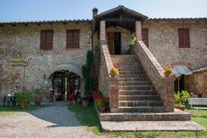 a stone building with stairs in front of a building at Albergo Ristorante Da Vestro in Monticiano