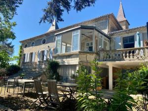 une maison avec des chaises et une table devant elle dans l'établissement Domaine Saint Martin le grand, à Béziers