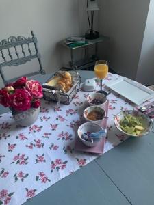 a table with some food and a glass of orange juice at LE Doux Nid La Classique in Saint-Aulaye