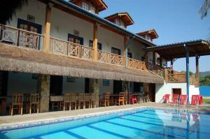 a resort with a swimming pool and a building at Pousada Aqui é Para-Ti in Paraty