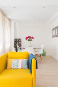 ein gelbes Sofa im Wohnzimmer mit einem Tisch in der Unterkunft Precioso Apartamento 2 hab. en Malaga Centro in Málaga