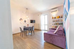 uma sala de estar com um sofá roxo e uma mesa em Boutique Apartment em Chiusi