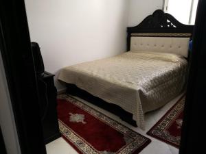 a bedroom with a bed and a red rug at bel appartement dans une residence calme in Martil