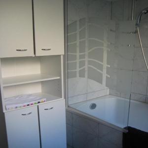 a white bathroom with a tub and a glass shower at Ferienwohnung Fritz in Villach