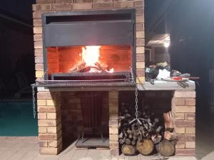 a brick fireplace with a fire in it at Meadows Guesthouse in Germiston