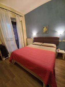 a bedroom with a large bed with a red blanket at Minisuite in Rome in Vitinia