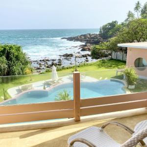 balcón con piscina y océano en Belika Beach Club, en Hiriketiya