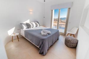 a bedroom with a bed and a large window at CAMPO SUITES in Kampos Paros