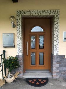 una puerta delantera de madera de una casa con ventana en Ferienwohnung Kendlbacher en Bischofshofen