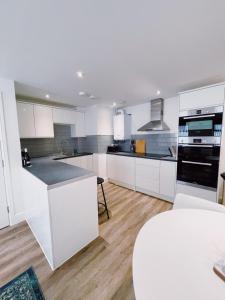una cucina con armadi bianchi e piano di lavoro di Prosper House Apartment 6 a Norwich