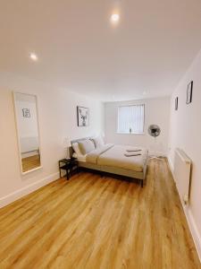 a bedroom with a bed and a wooden floor at Prosper House Apartment 6 in Norwich