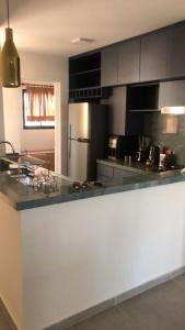 a kitchen with a counter top and a refrigerator at Apartamento Aquaville Resort Vista Mar próximo Beach Park Ceará in Aquiraz