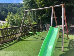 a playground with a green slide in a yard at Bar Hotel Restaurant le Margeriaz in Les Déserts