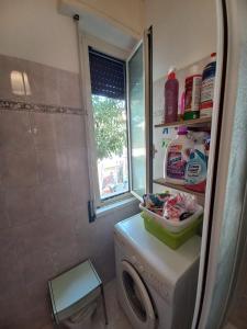 a small bathroom with a washing machine and a window at Minisuite in Rome in Vitinia