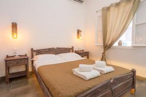 a bedroom with a bed with two towels on it at Family Villages Santorini in Vlychada Beach