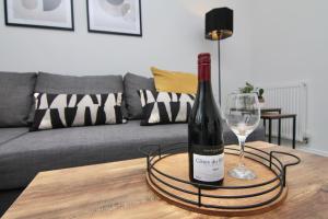 a bottle of wine and a wine glass on a table at Dashing 2Bed Haven - Near Coventry Centre, Free Parking in Coventry