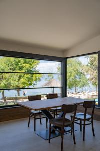 a dining room with a table and chairs and a large window at Lago Hotel in Ohrid