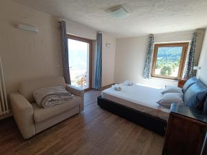 Un dormitorio con una cama y un sofá y una ventana. en Les Flocons Pila, en Pila