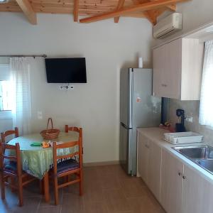 a kitchen with a table and a refrigerator at Avocado house in Finikounta