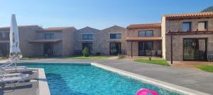 a house with a swimming pool in front of a house at Petrina Bolosis in Palaiókastron