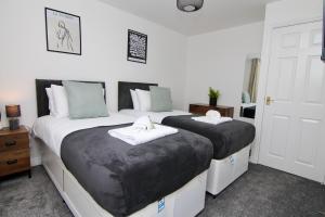 a bedroom with two beds with black and white sheets at Dashing 2Bed Haven - Near Coventry Centre, Free Parking in Coventry