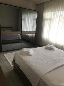 a bedroom with a large bed and a mirror at Doğa apart 