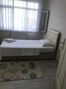 a bedroom with a bed with a window and a rug at Doğa apart 