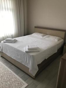 a bed with two towels on it in a bedroom at Doğa apart 