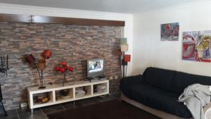 a living room with a couch and a brick wall at Zen Guest House em Leiria in Pedrógão Grande