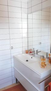 ein weißes Badezimmer mit einem Waschbecken und einem Spiegel in der Unterkunft Zen Guest House em Leiria in Pedrógão Grande