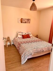 1 dormitorio con 1 cama con edredón en Désirée, en Le Bosc