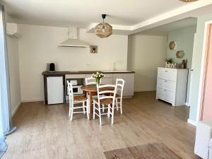 een keuken en eetkamer met een tafel en stoelen bij Désirée in Le Bosc