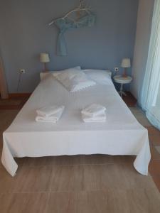 a white bed with white sheets and towels on it at Palio Villa in Paleo Tsifliki