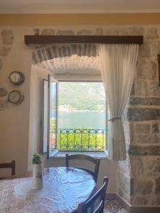 a dining room with a table and a window at Captain's House in Dobrota in Kotor
