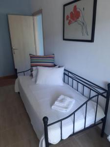 a bed with a black frame and white sheets and pillows at Palio Villa in Paleo Tsifliki