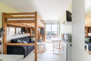 a living room with a bunk bed and a kitchen at L'Effet Mer in La Richardais