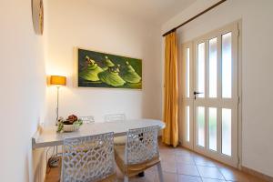 a dining room with a table and chairs and a window at Bonsai B&B Alghero in Santa Maria la Palma